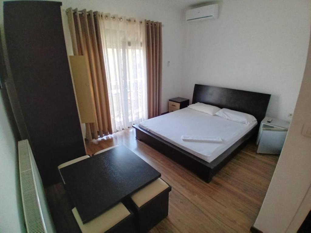 Habitación pequeña con cama y mesa en Hotel Unik, en Pogradec