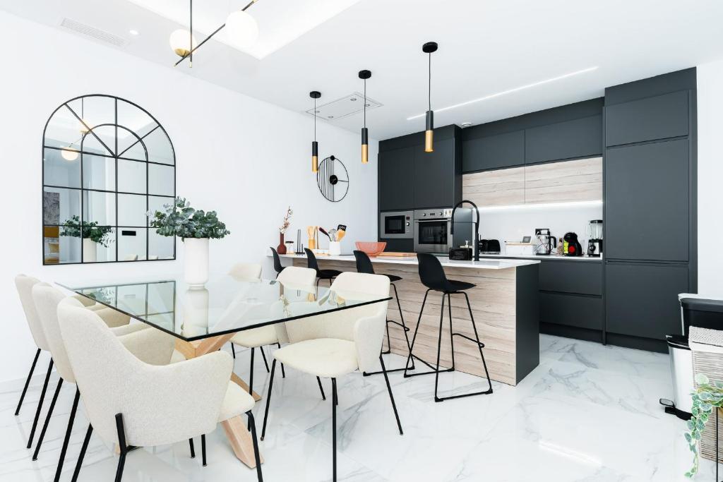 a kitchen with a glass table and white chairs at Moderna Casa VillaCristal in Daya Vieja