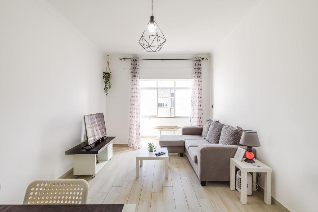 ein Wohnzimmer mit einem Sofa und einem Tisch in der Unterkunft Sleeptubal Moderne Accommodatie in Alhos Vedros