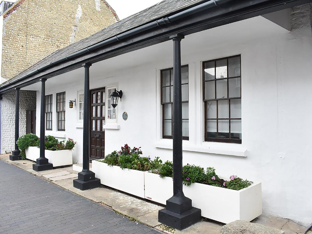 a white house with two windows and plants at Ukc4174 The Cottage By The Sea in Littlehampton