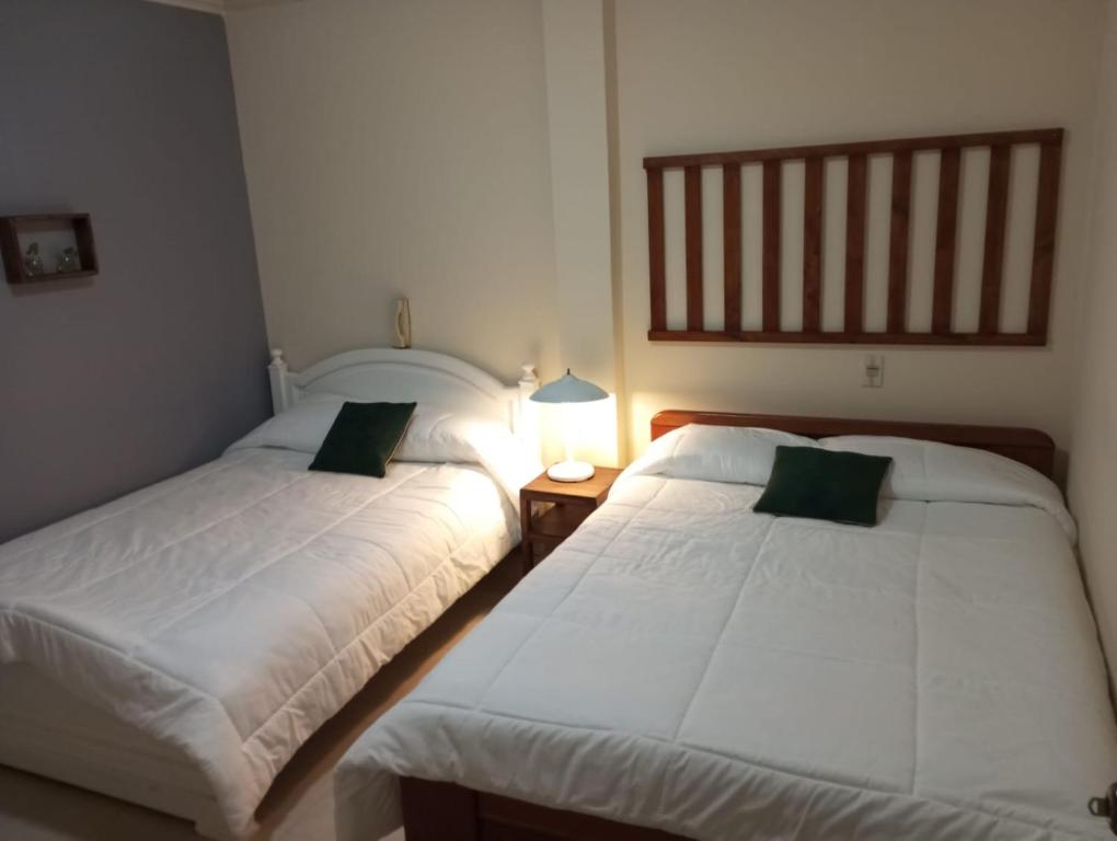 two beds sitting next to each other in a bedroom at Mini suite in Loja