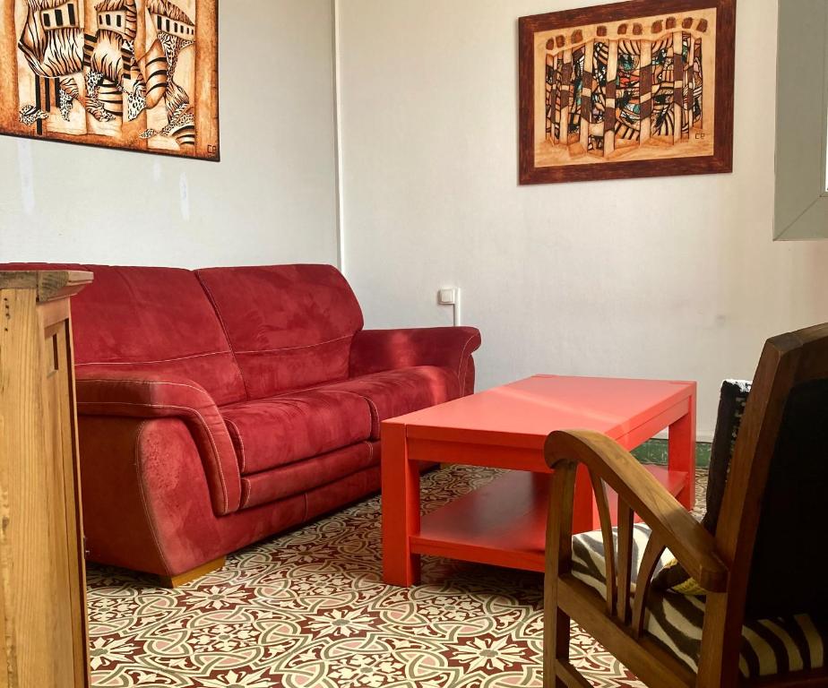 un salon avec un canapé rouge et une table dans l'établissement Danoss Cool Stay, à Narbonne