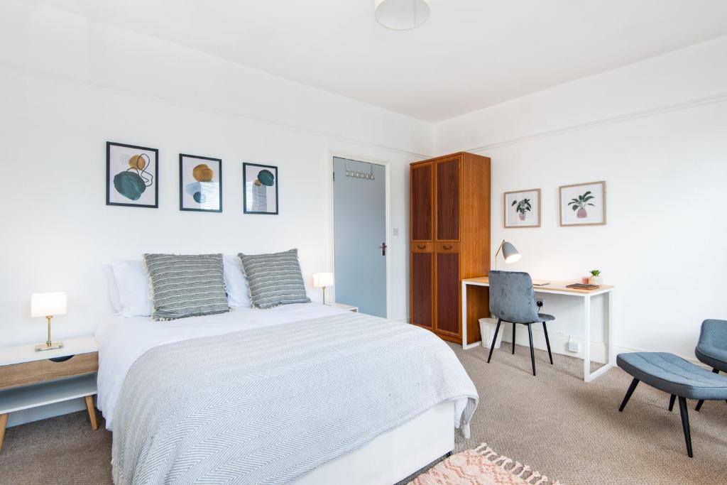 a white bedroom with a bed and a desk at King Room with a shared Kitchen and bathroom in a 5-Bedroom House at Hanwell in Hanwell