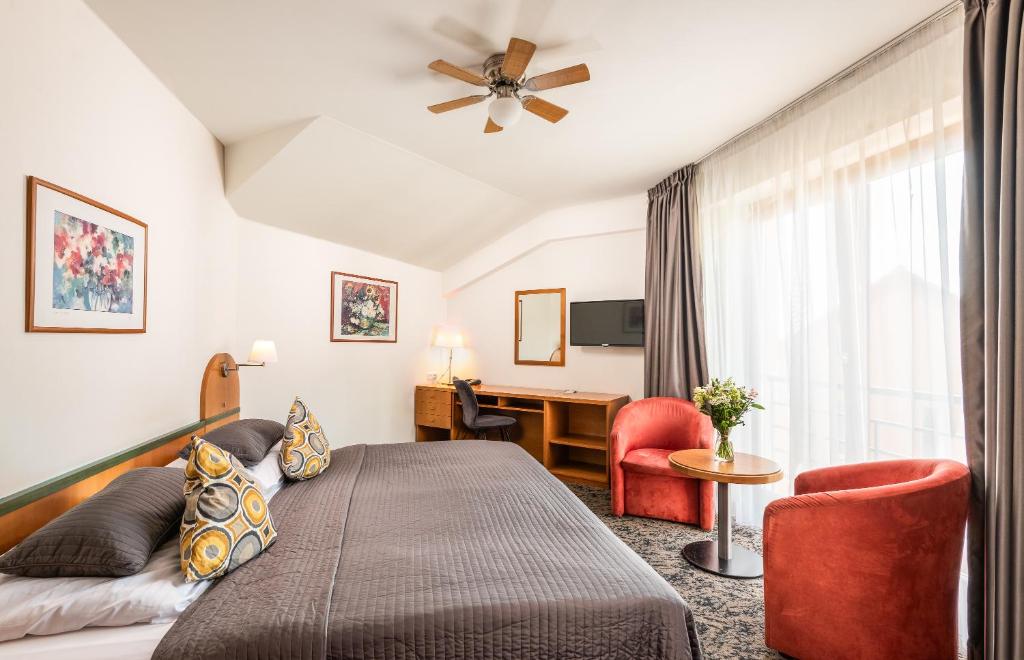 プラハにあるホテル トロヤのベッドとデスクが備わるホテルルームです。