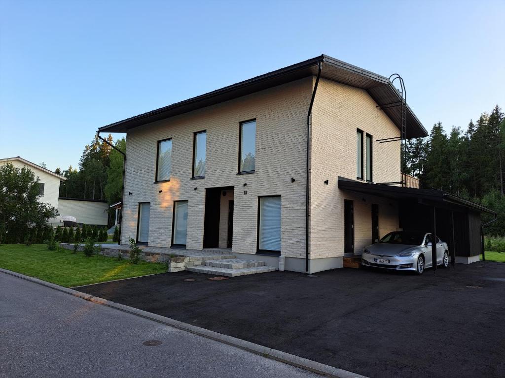 una casa con una macchina parcheggiata in un parcheggio di VILLA MARIA a Turku