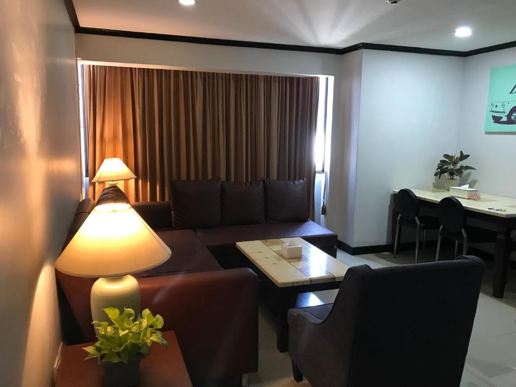 a living room with a couch and a table at Omnitower two bedroom cozy apartment in Bangkok
