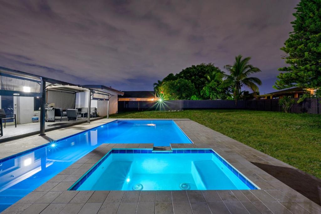 a swimming pool in the backyard of a house at night at Private Spacious House #BBQ - Hallandale Beach, Florida in Hallandale Beach
