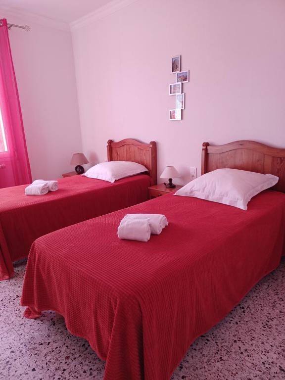 Cette chambre comprend 2 lits avec des draps rouges et des oreillers blancs. dans l'établissement Gîte La Charité à proximité de Roussillon, Gordes, à Gargas