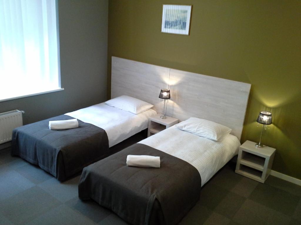 een hotelkamer met 2 bedden en 2 lampen bij Nostalgia in Rīga