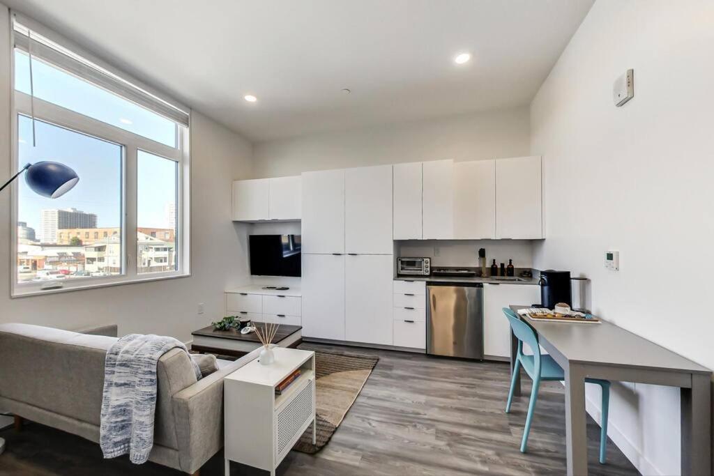 a kitchen and living room with a couch and a table at Brand New Stylish Studio Suite Near Downtown in Oakland