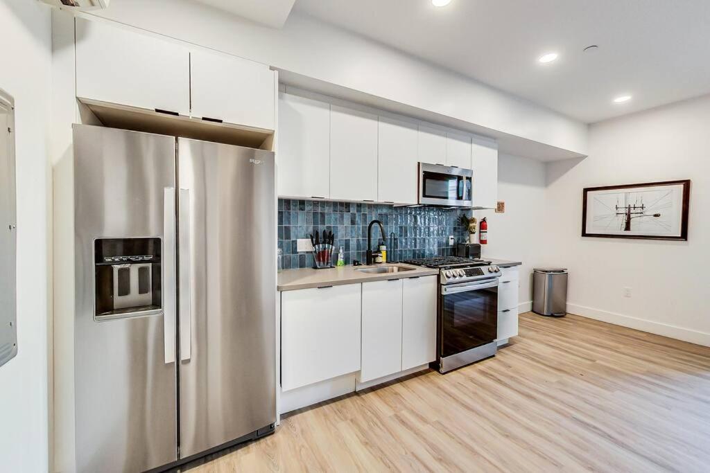 a kitchen with white cabinets and a stainless steel refrigerator at Studio Suite Close to Downtown in Oakland