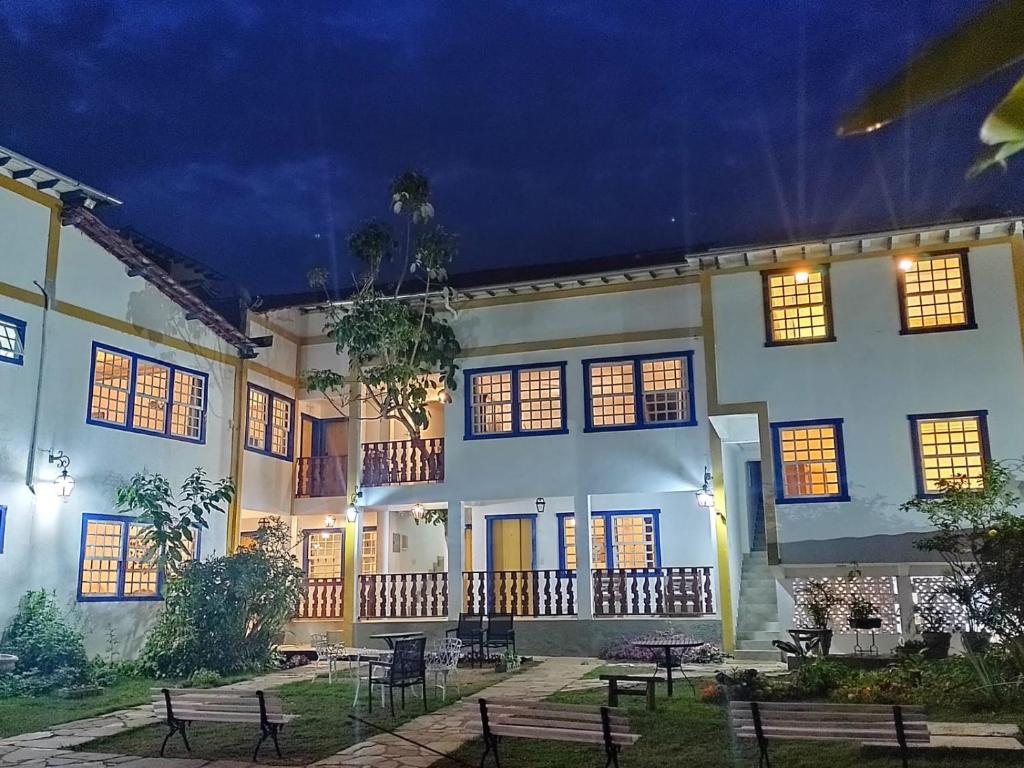 a building with benches in front of it at night at Tiradentes Pousada Ramalhete in Tiradentes