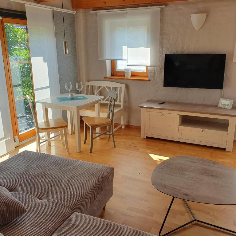 een woonkamer met een televisie en een tafel met stoelen bij Ferienwohnung RELAX in Neudrossenfeld