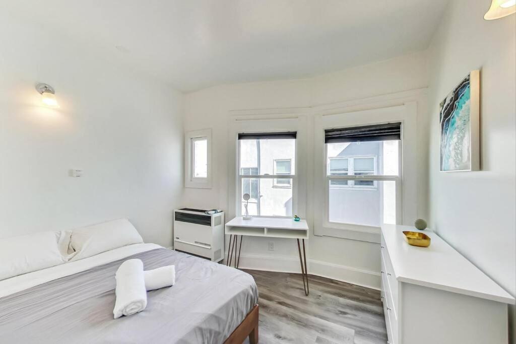 a bedroom with a bed and a desk and windows at Best Location 3BR by UCBerkeley in Berkeley