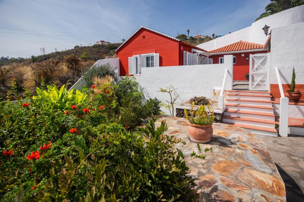 een rood-wit huis met planten en bloemen bij Casa El Drago 2 in Breña Baja