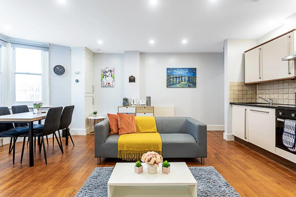 a living room with a couch and a table at Bright St Johns Apartments in London