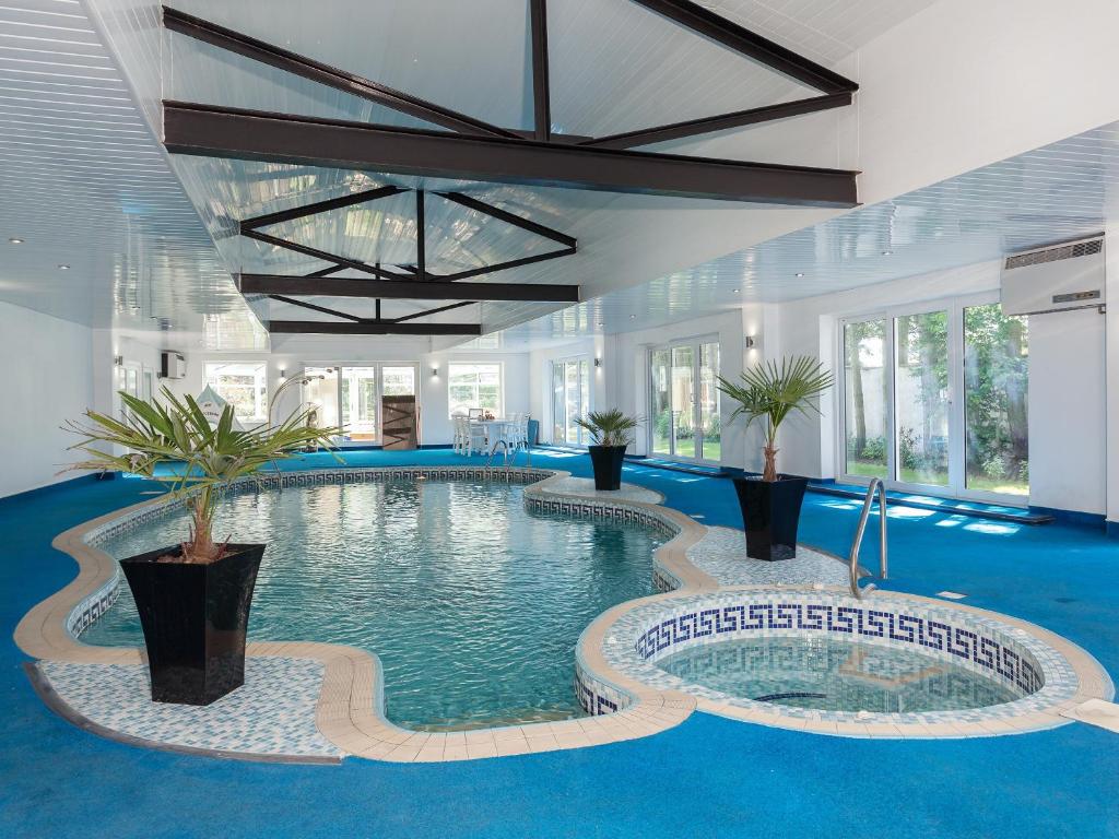 a large swimming pool in a building with blue floors at Buttercup Cottage in Halsall