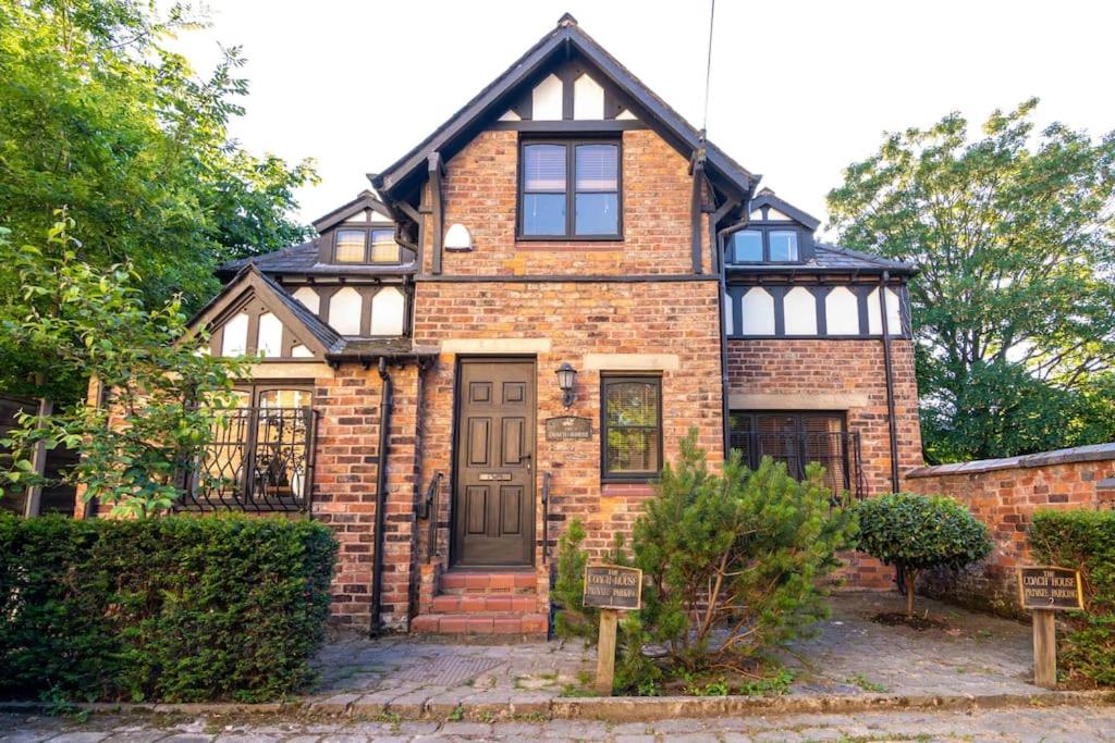 a brick house with a black roof at Detached house with gated parking in Whalley Range in Manchester