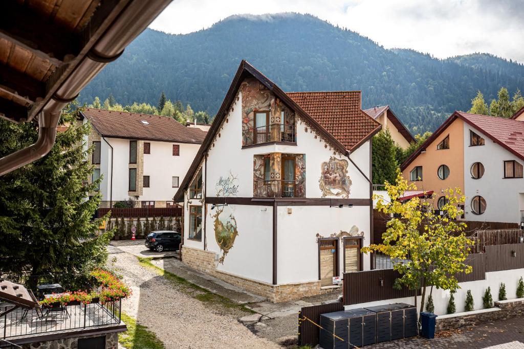 a house in a village with mountains in the background at Monti Chalet in Poiana Brasov