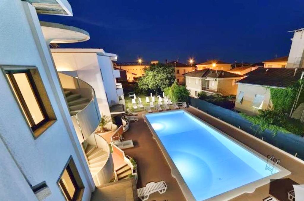 a swimming pool in the backyard of a house at night at Residence with swimming-pool in Marina di Cecina just 700 meters from the beach in Cecina