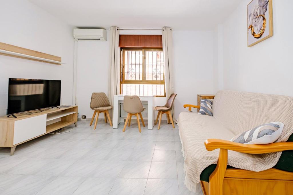 una sala de estar con un sofá y un televisor en Joven Pura ID134, en Torrevieja