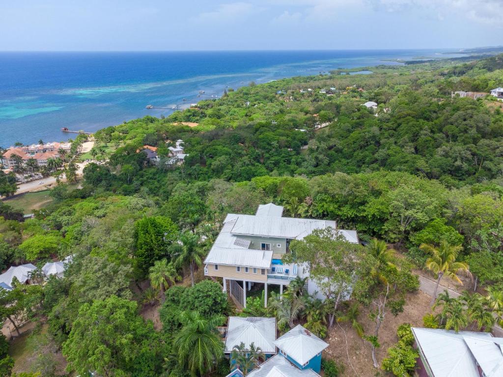 een luchtzicht op een huis op een heuvel naast de oceaan bij Casa Afortunada - 2 bedrooms in Sandy Bay