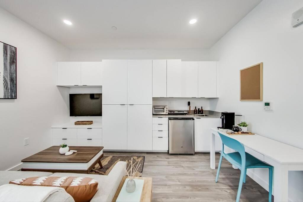 a kitchen with white cabinets and a table and a couch at Brand New Studio Near Downtown in Oakland