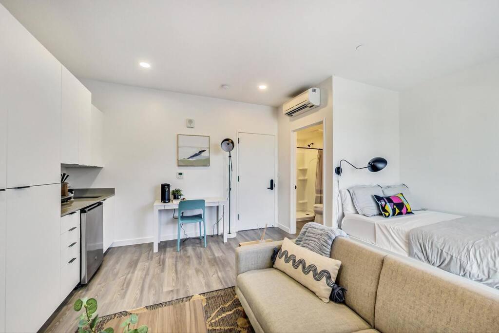 een woonkamer met een bank, een bed en een bureau bij Stylish Studio in Laney-Peralta in Oakland