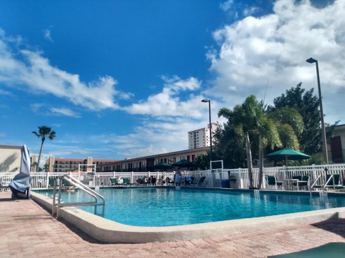 a large swimming pool with blue water in a city at Ocean Landings Resort & Racquet Club in Cocoa Beach