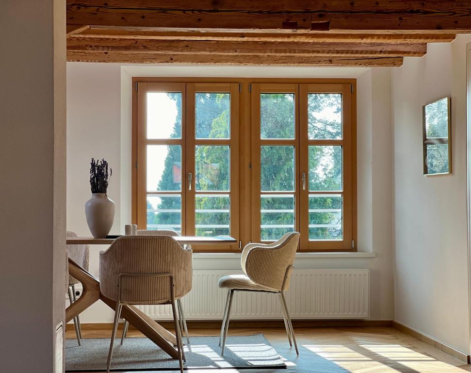 a dining room with two chairs and a window at Ferienzauber 1897 in Dornbirn