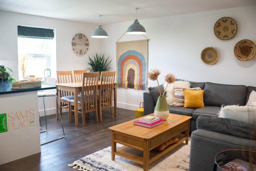 ein Wohnzimmer mit einem Sofa und einem Tisch in der Unterkunft Sam's Place Apartment in Uppingham, Rutland in Uppingham