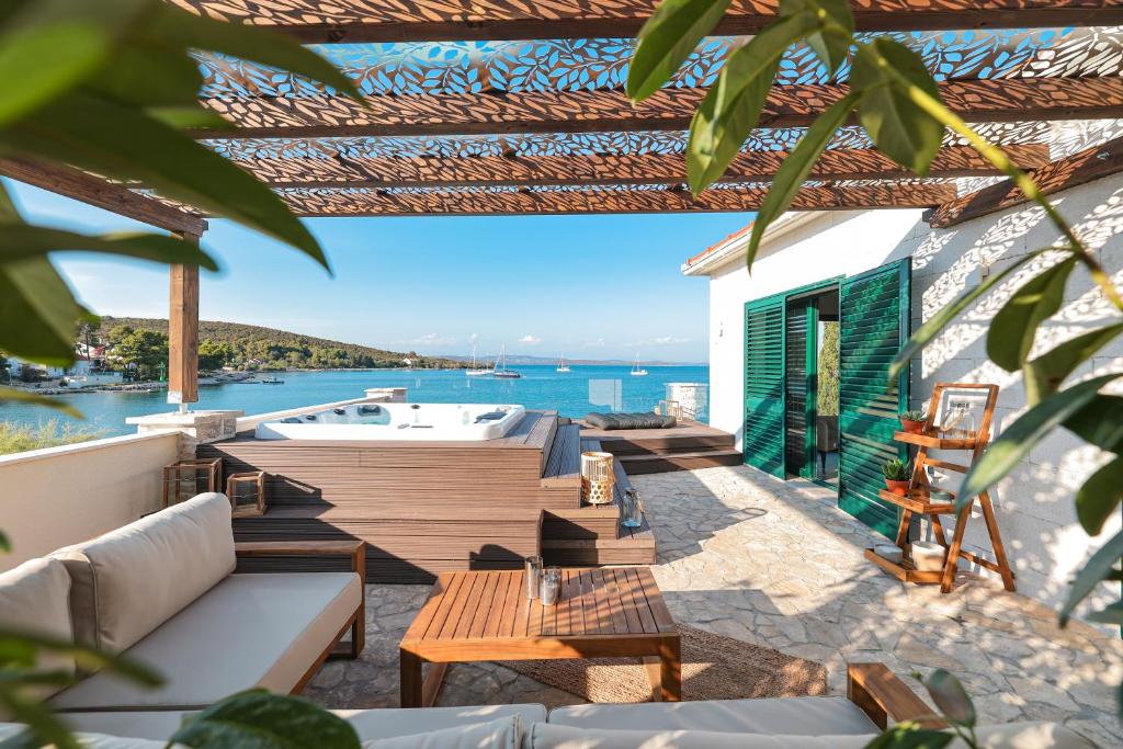 un patio con muebles y vistas al agua en Villa Mare Vista, en Žman