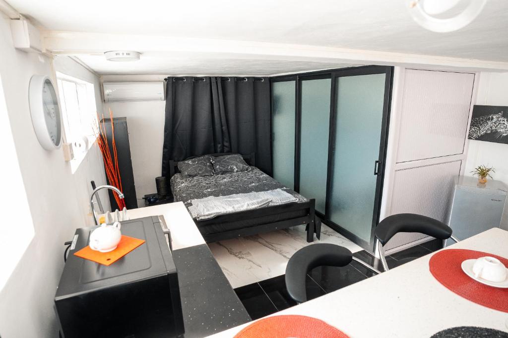 um pequeno quarto com uma cama e uma mesa em Studio B em Port Louis