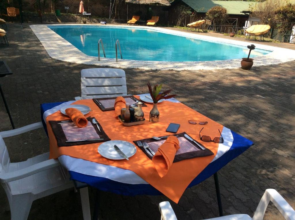 uma mesa com um prato de comida ao lado de uma piscina em The Landmark Boutique Hotel em Blantyre
