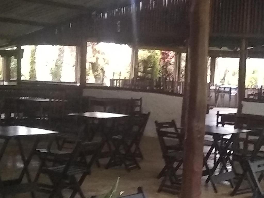 an empty restaurant with tables and chairs and windows at Clube de Camping Ana Paula in São Paulo