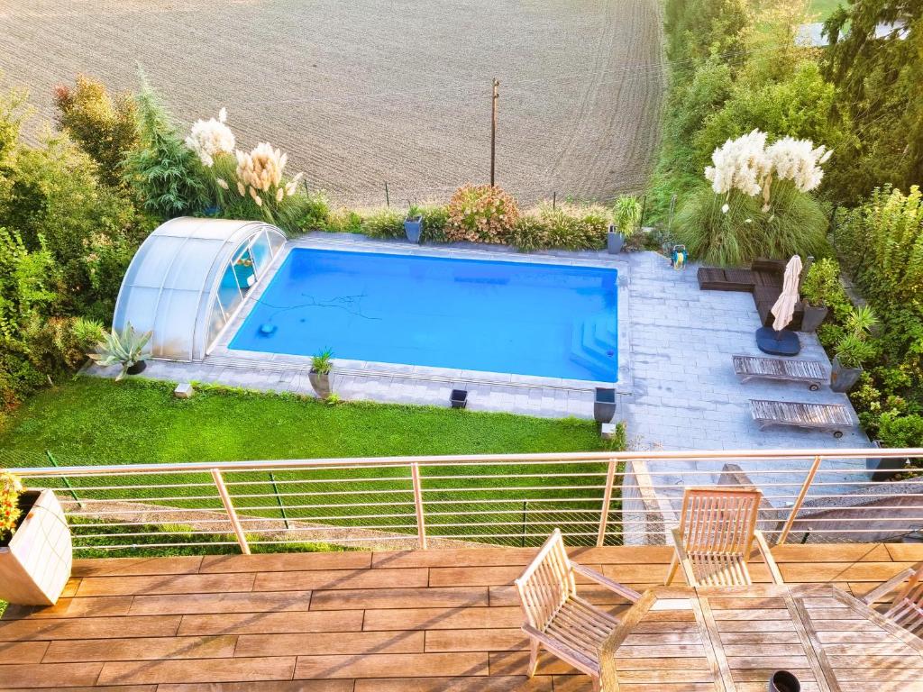 uma piscina num quintal com duas cadeiras e uma mesa em Mountains and Lakes - Villa Gaumberg em Linz