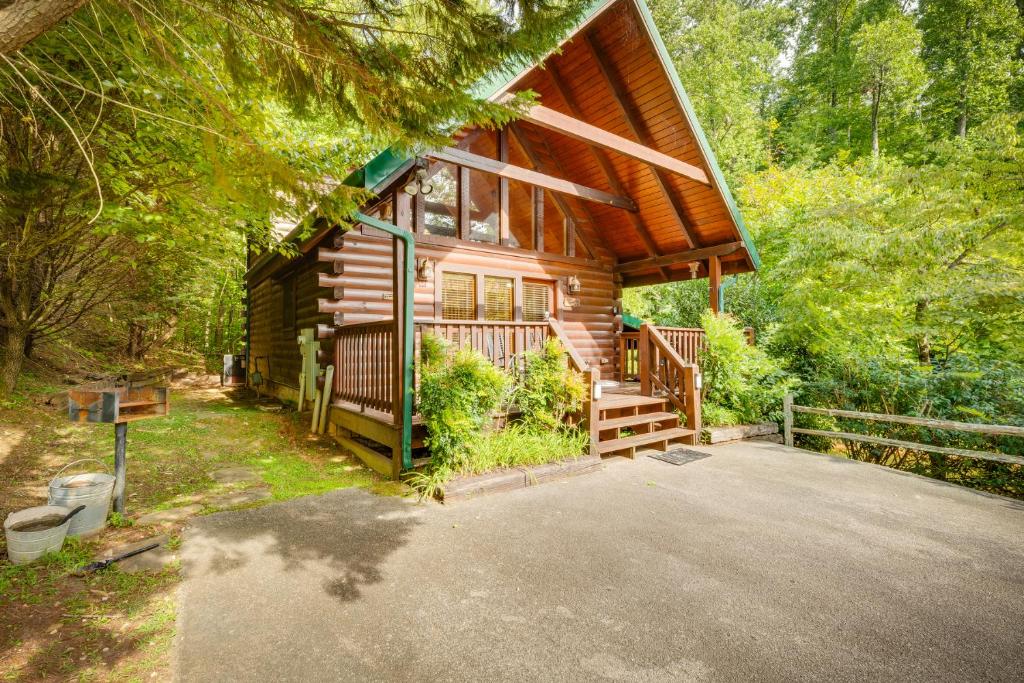 a log cabin with a porch and stairs to the front at Hugs N Kisses Pool Table Hot Tub Pool Table Community Pool Close to Downtown Gatlinburg in Gatlinburg
