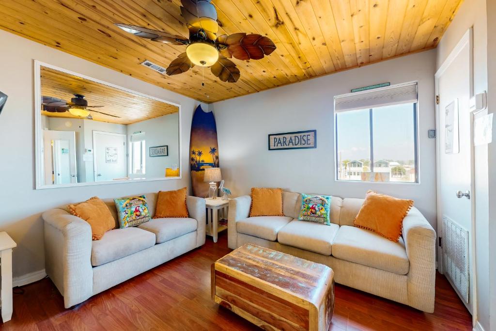 een woonkamer met 2 banken en een houten plafond bij Sand Castle Villa #26 in Panama City Beach