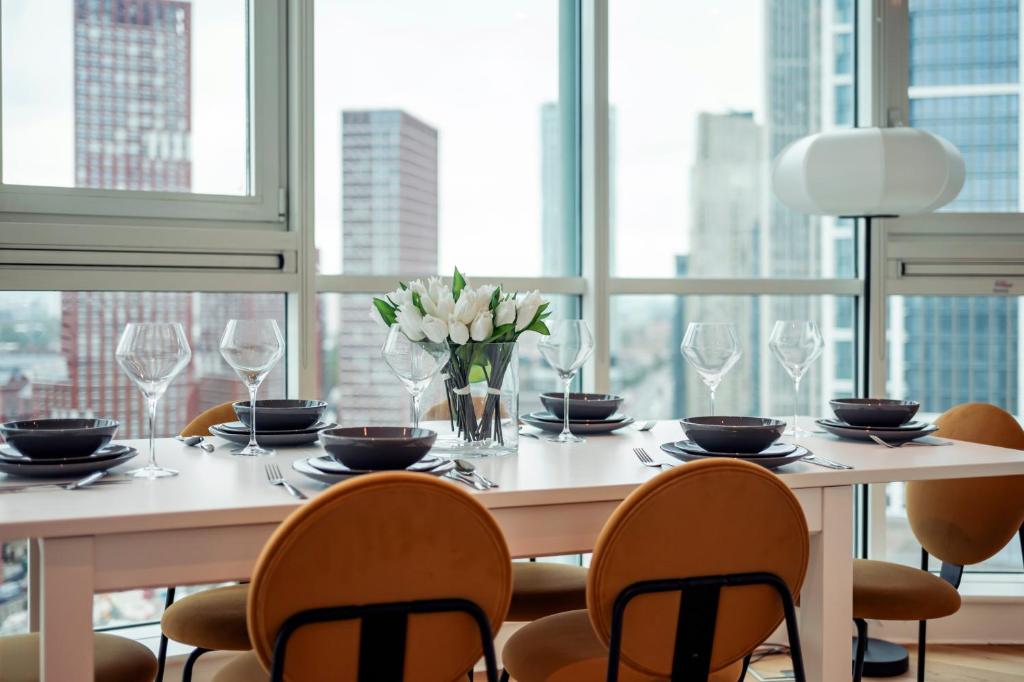 a dining room table with chairs and a large window at Vauxhall Skyline Apartment in London