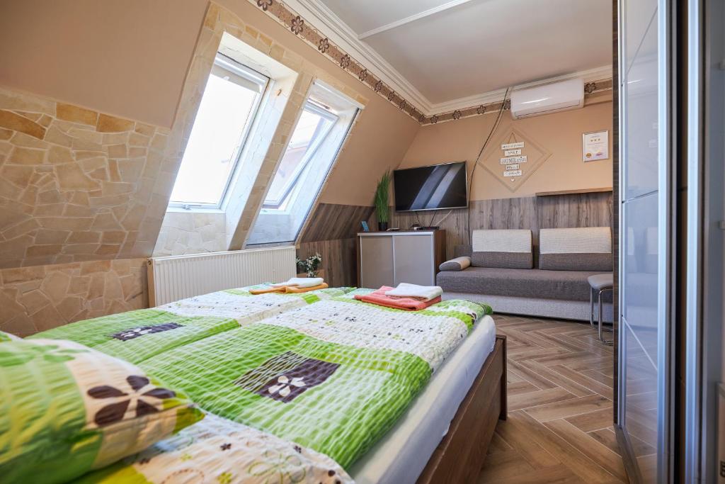 sypialnia z dużym łóżkiem i kanapą w obiekcie Valentin Deluxe Apartman w Hajduszoboszlo