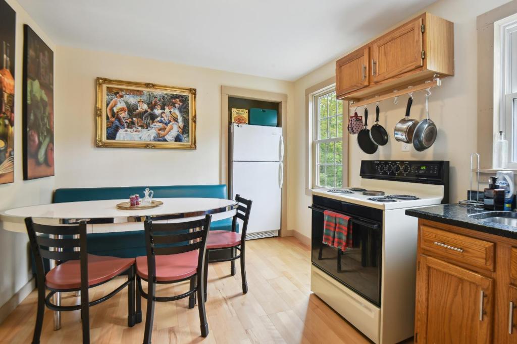 uma cozinha com uma mesa, cadeiras e um fogão em Hillsborough Village Retreat Walk to River! 
