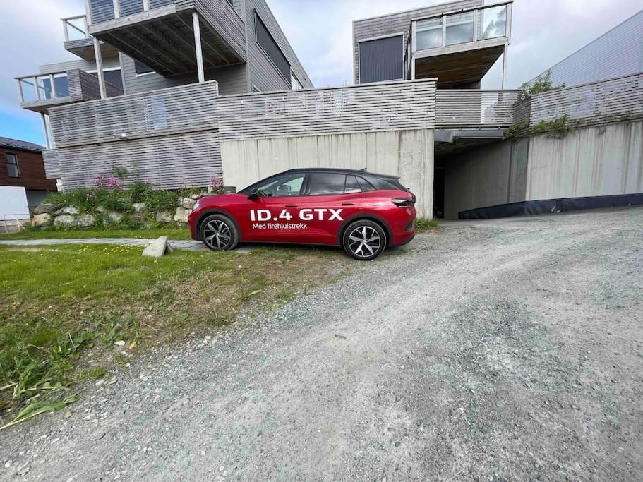 a red car parked in front of a garage at Cozy central home, quiet neighbourhood in Tromsø