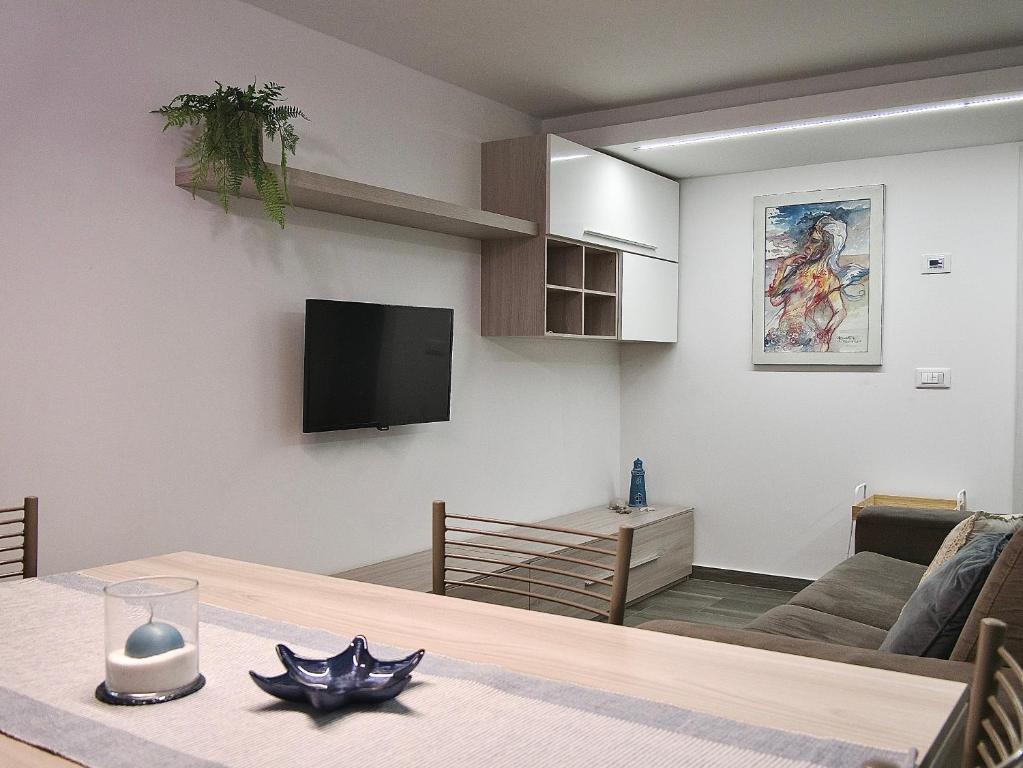 een woonkamer met een tafel en een televisie bij THE BAC HOUSE - Maestrale in Fano