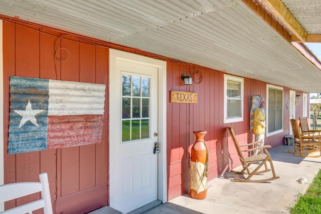 Una casa roja con una bandera americana. en On 60-Acre Farm with Pond Charming Carmine Studio!, en Carmine