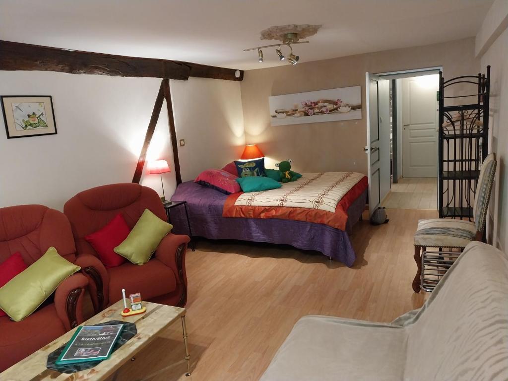 een woonkamer met een bed en een bank bij La CRAPOUNETTE in Pierry