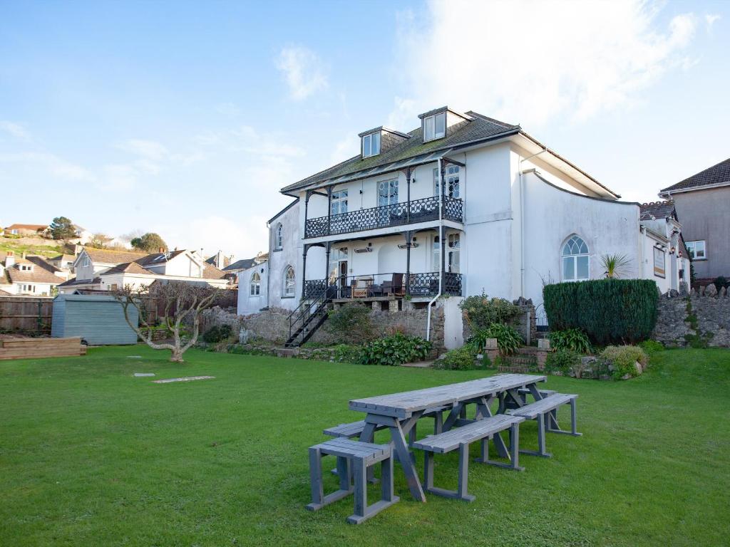 a group of picnic tables in front of a house at Ranscombe House in Brixham