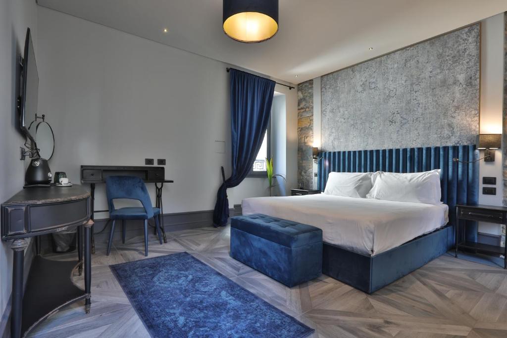 得利雅斯特的住宿－FORVM bijoux ROOMS，配有一张床和一张书桌的酒店客房