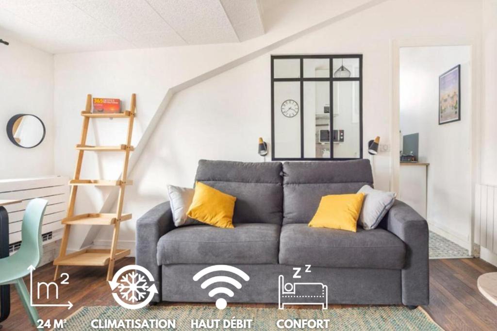 a living room with a gray couch with yellow pillows at La parenthèse sous les toits in Fontainebleau