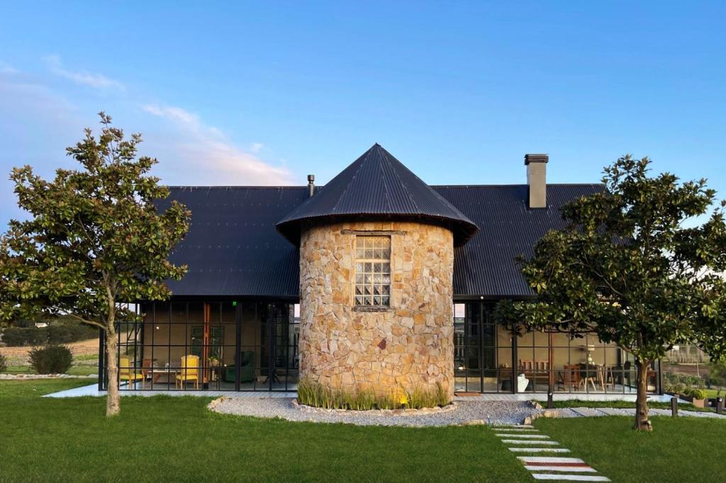 a building with a stone building with a black roof at ROCCHETTA HOTEL BOUTIQUE in Sierra de los Padres