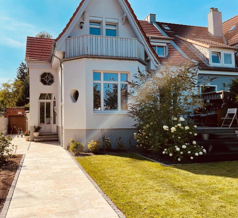 una casa blanca con un patio de césped en Villa am Strand, en Eckernförde
